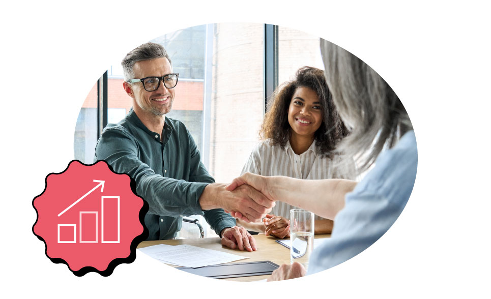 A man and a woman shake hands during a business meeting.