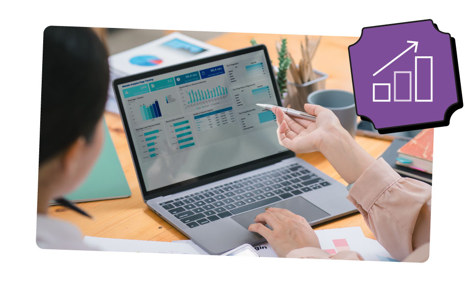 A research team member points to they laptop screen displaying various graphs and figures.