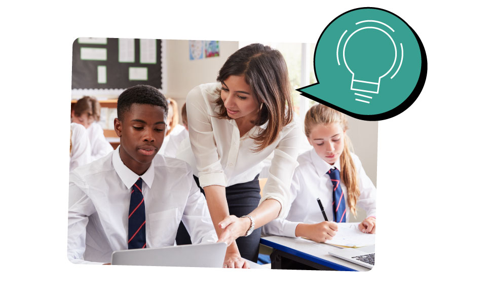 A female teacher helps a student with his work in a classroom