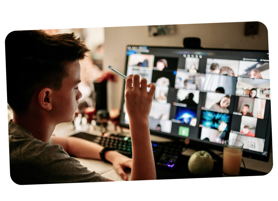 A teenage boy holding a pen whilst working with other young people on a group call
