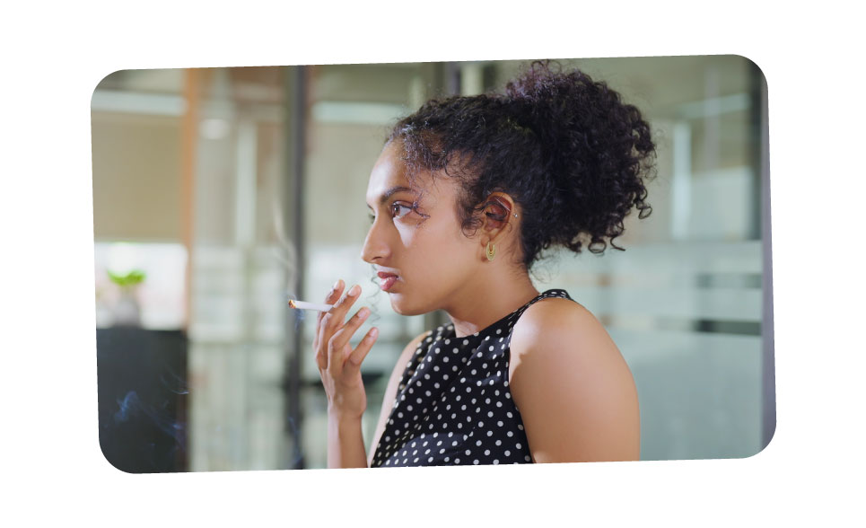 A young girl smoking a cigarette indoors.