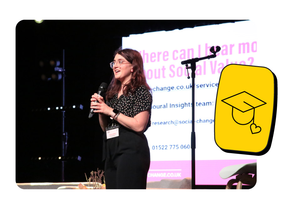 Head of Research Daisy speaking at a live training event on stage.