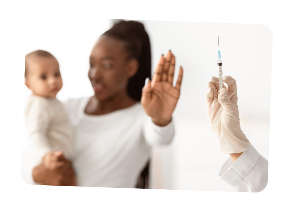 A person wearing gloves holds a syringe while another person holding a child raises a hand in a gesture of refusal.