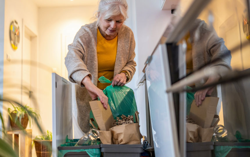 A young boy places a glass jar into the glass deposit box.