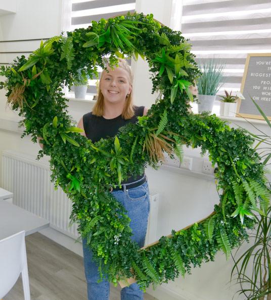 Amelia holding a large letter B made from leaves