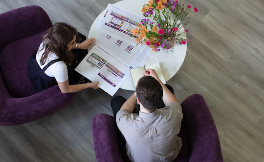 Jake and Daisy looking at JustBe Croydon design concepts in the Social Change UK office