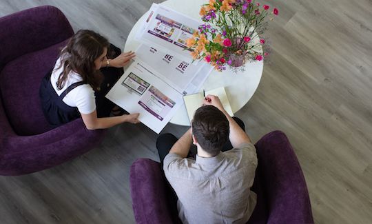 Jake and Daisy looking at JustBe Croydon design concepts in the Social Change UK office