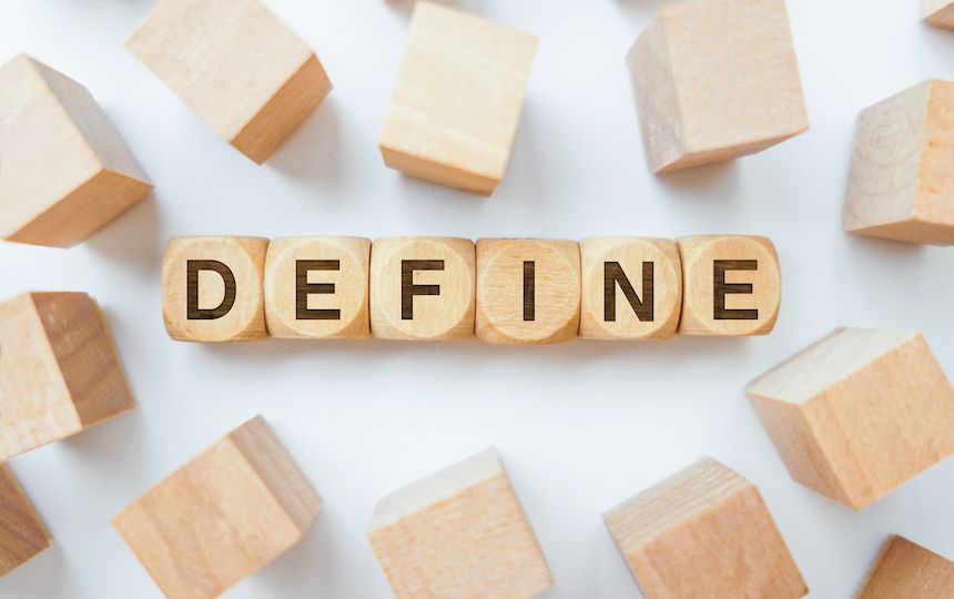 Various wooden blocks are scattered, with six wooden dice sized in the middle spelling 'define'.