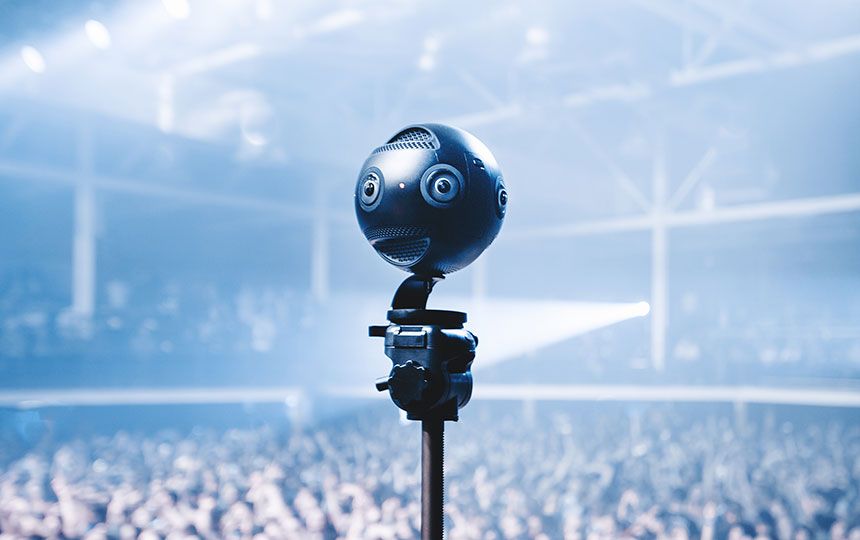 A small metal ball with built-in cameras and microphones is overlooking a large concert crowd.