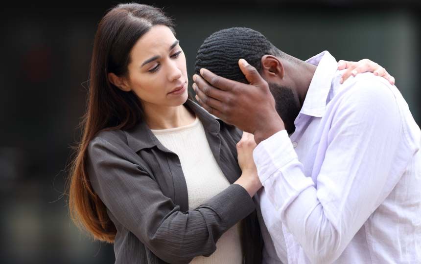A woman supporting an upset male freind.
