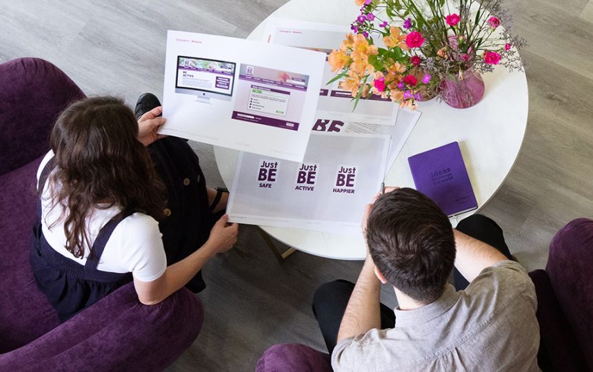 A birds eye view of Jake and Daisy discussing a project in the Social Change UK office.