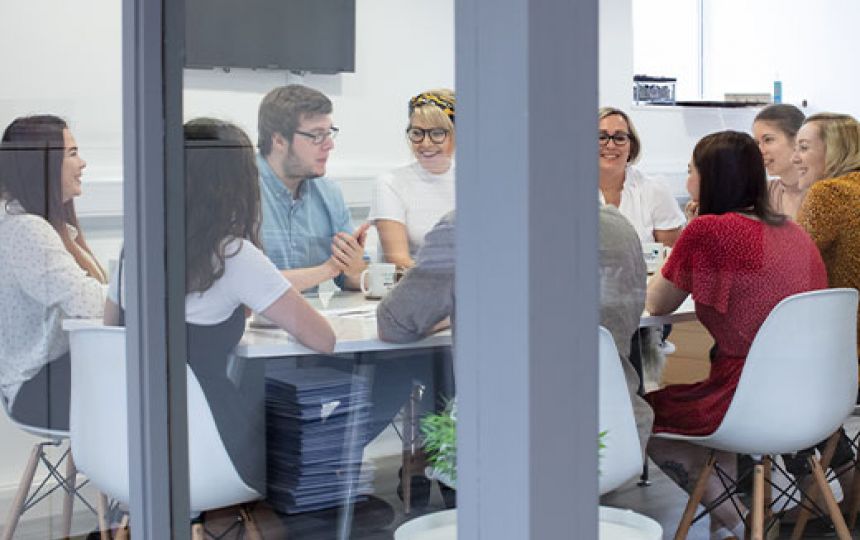 The Social Change UK team happily discussing ideas in the meeting room.