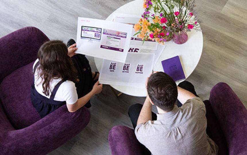 A birds eye view of Jake and Daisy discuss a project in the Social Change UK office.
