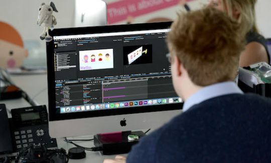 Changemaker Bobby has his back to the camera and works on an animation on his computer.
