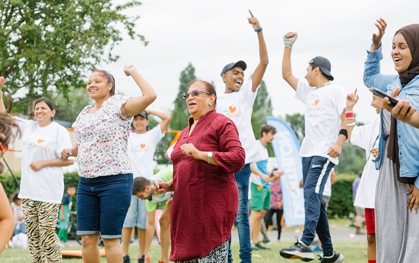 People, young and old, jumping and dancing at a social gathering.