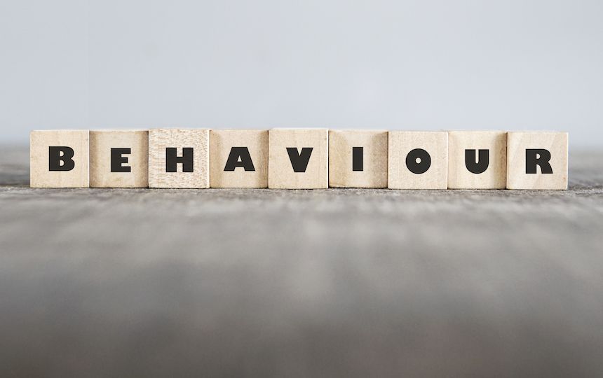 A line of wooden cubes with letters on them that spell out 'behaviour'.