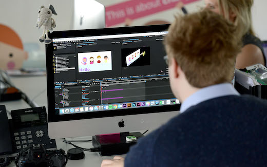 Changemaker Bobby has his back to the camera and works on an animation on his computer.