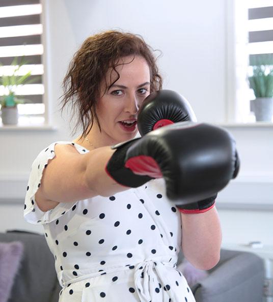 Ellen, Social Change UK's PR and Communications Manager wearing boxing gloves