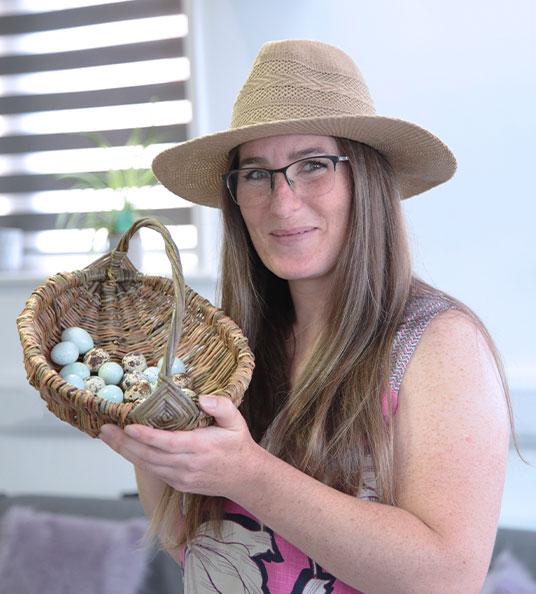 Julie, Social Change UK's Senior Marketing Manager holding a basket of Quails eggs.