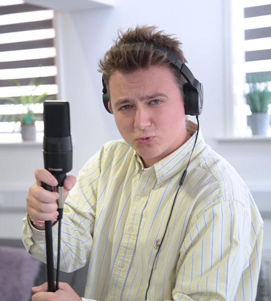 Max, Social Change UK's Content Producer posing with a microphone