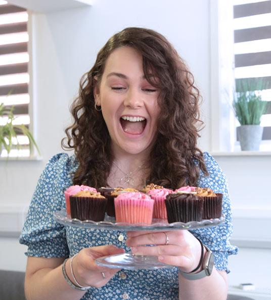 Megan, Marketing Executive with a plate of cakes.