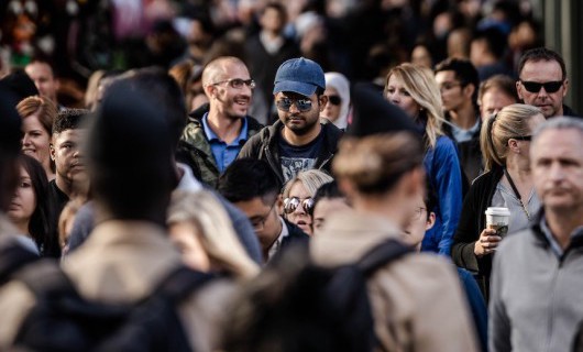 A crowd of people walking down a busy street.