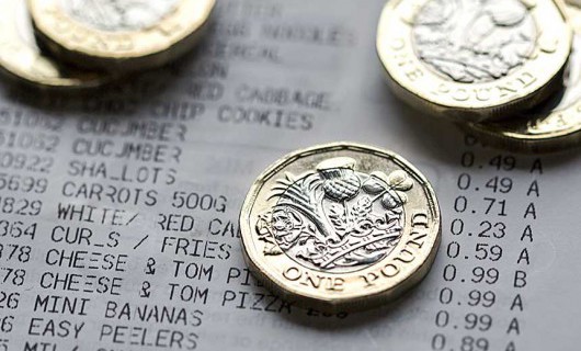 A close up image of five £1 coins on top of a receipt.
