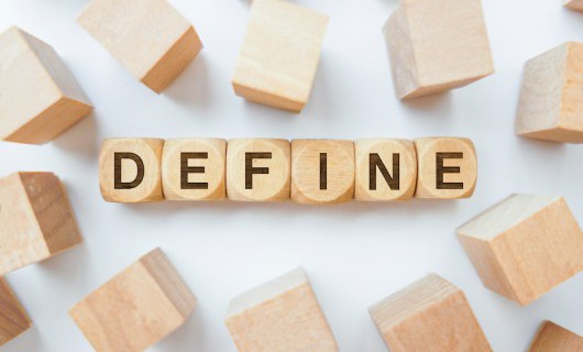 Various wooden blocks are scattered, with six wooden dice sized in the middle spelling 'define'.