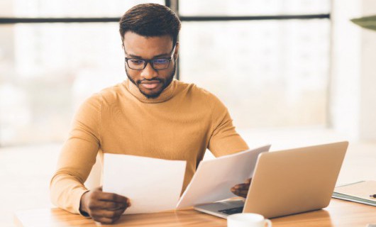 A person reading papers at a desk.