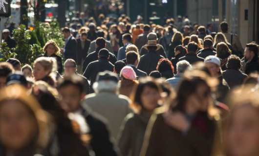 A crowd of people walking in a street.