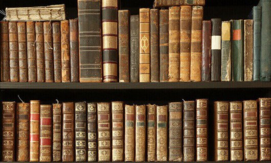 A number of old books on a bookshelf.