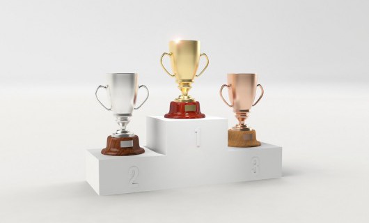 A podium displays the positions 1st, 2nd and 3rd, topped with bronze, silver and gold cups.