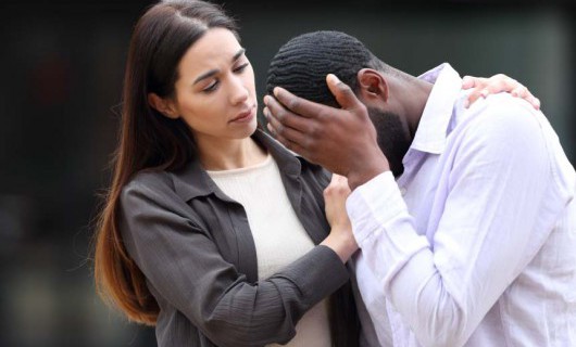 A woman supporting an upset male freind.