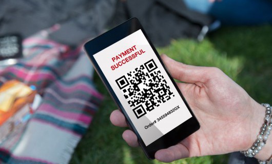 A QR code is shown on a smartphone.