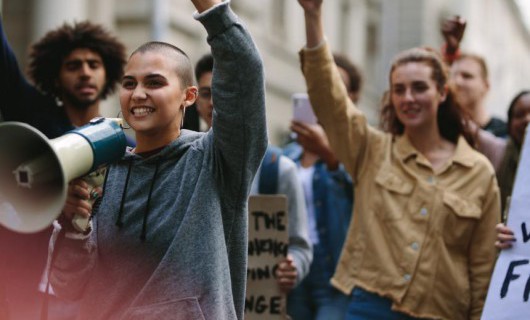 A group of activists with signs and a megaphone.