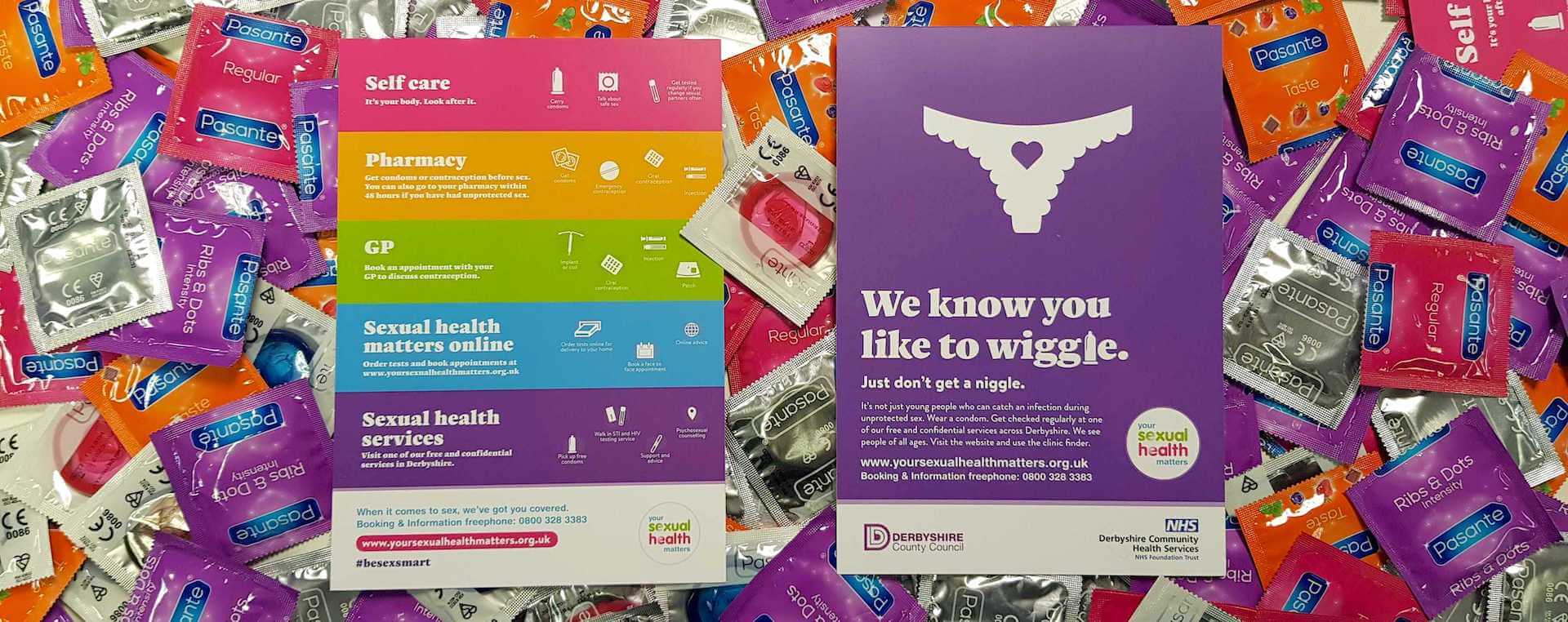 Brightly coloured flyers from the 'Your Sexual Health Matters campaign' on a pile of condoms.