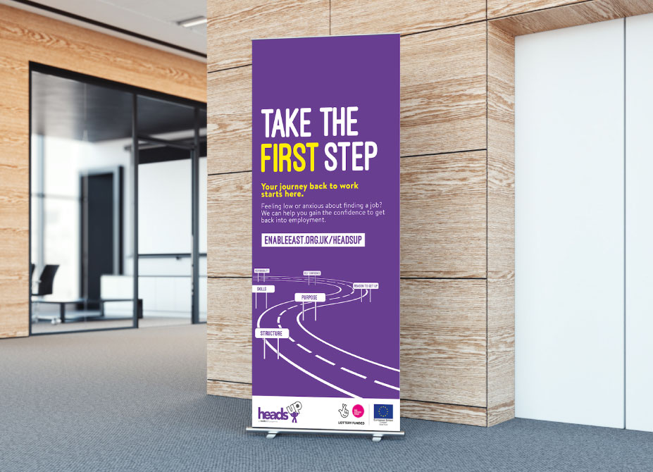 A HeadsUp branded roller banner placed in a corridor.