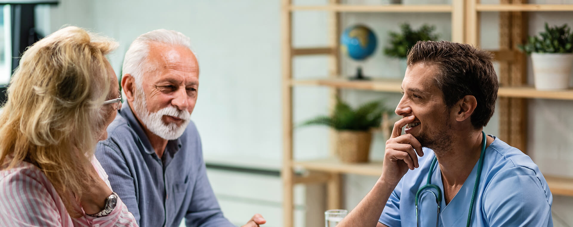 An elderly couple chats with their doctor.