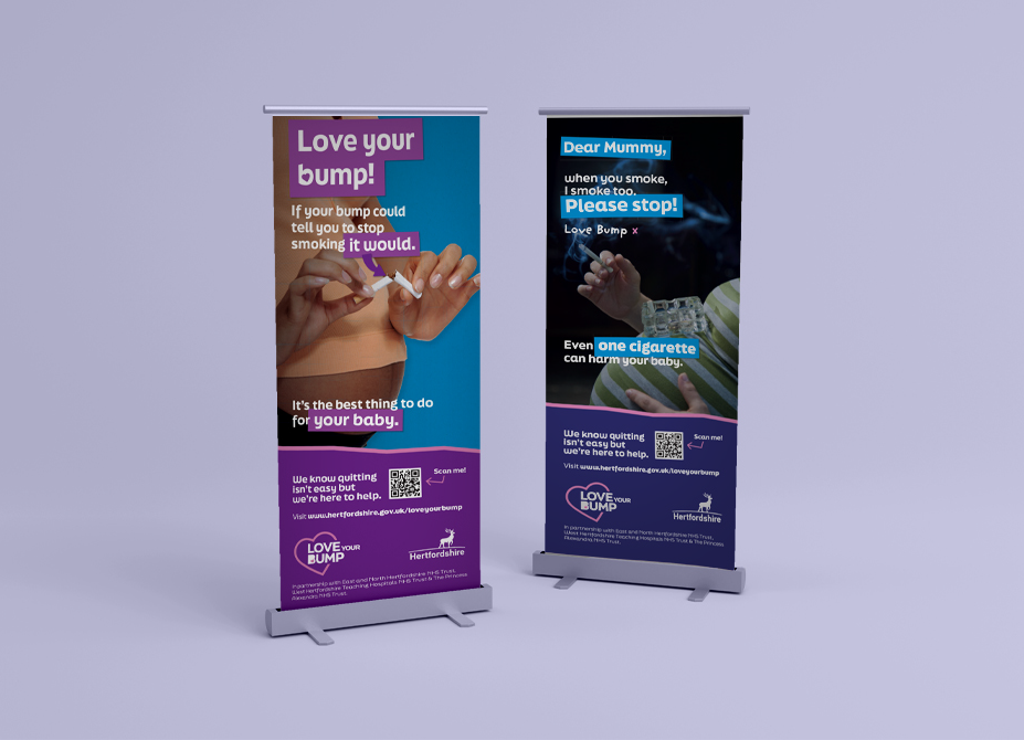Two campaign branded pop-up banners against a light purple backdrop showing a pregnant woman snapping a cigarette in half and another smoking a cigarette.