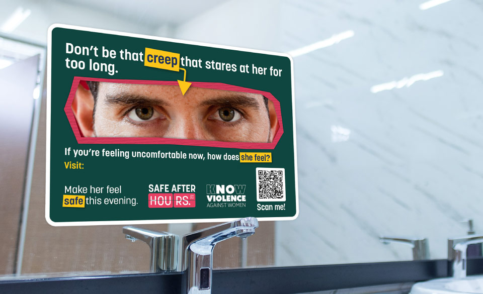 A campaign branded vinyl sticker placed on a mirror in a men's public toilet
