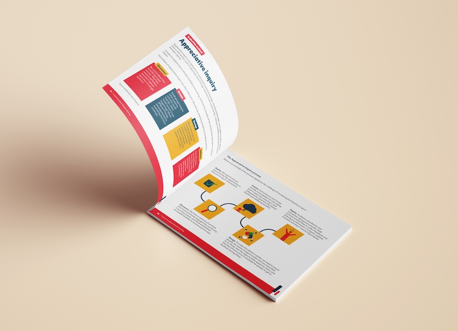 The Sport Wales guide opening at an angle on a pale yellow surface. The pages reveal various infographics.