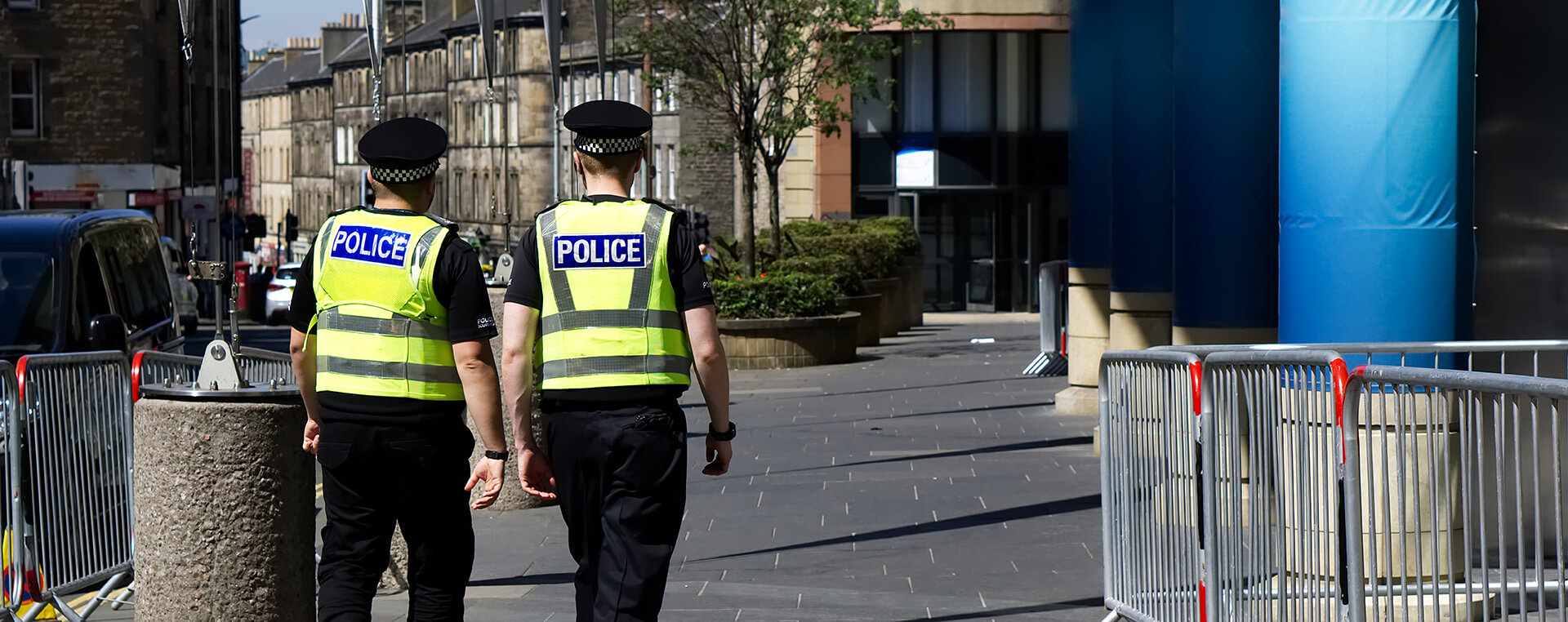 Two police officers patrolling together in a city centre street.