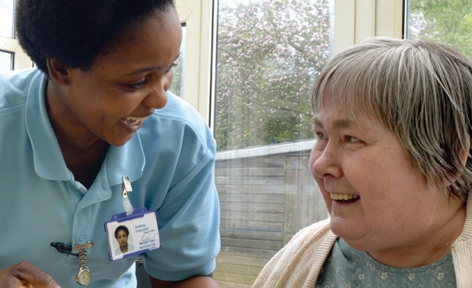 A caregiver and care user laughing and smiling with each other.