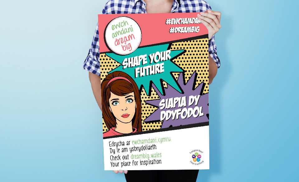 Someone holds an illustrated, pop-art style bilingual campaign poster.