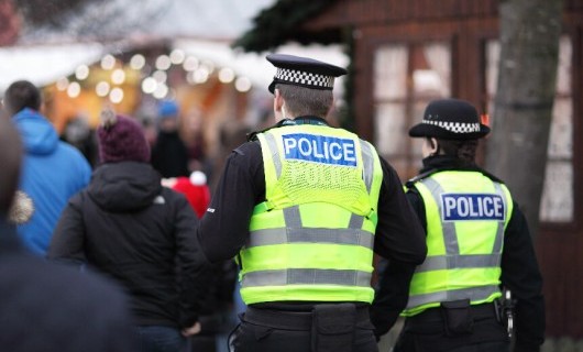 A male and female police officer on patrol during a winter event.
