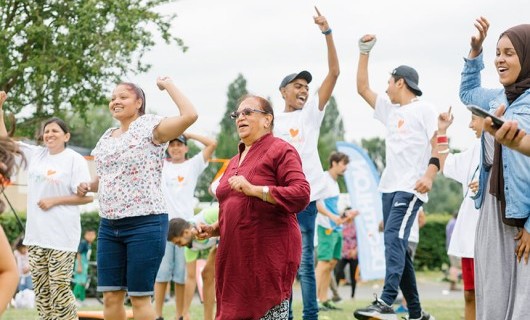 People, young and old, jumping and dancing at a social gathering.
